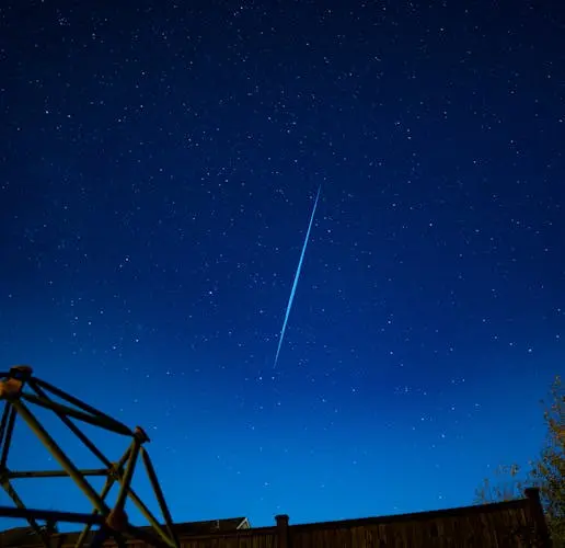 A breathtaking view of a meteor streaking through a star-filled night sky, highlighting the beauty of astronomy.
